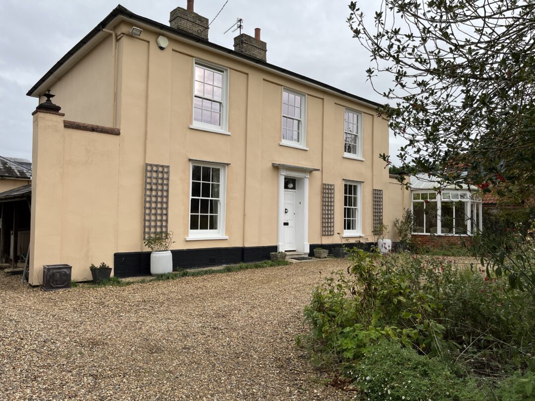 1884 llisted property with white historic style timber sliding sash windows painted in white with narrow double glazing and window bars.