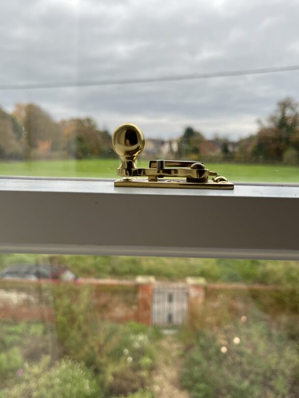 close up of sash fastener in polished brass