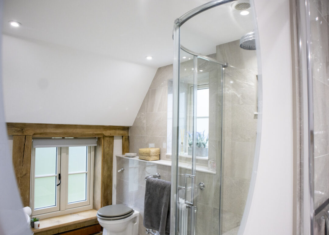 Shower room with exposed beams and timber window