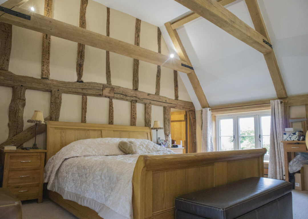 Bedroom with exposed beams and vaulted ceiling and low timber casement window