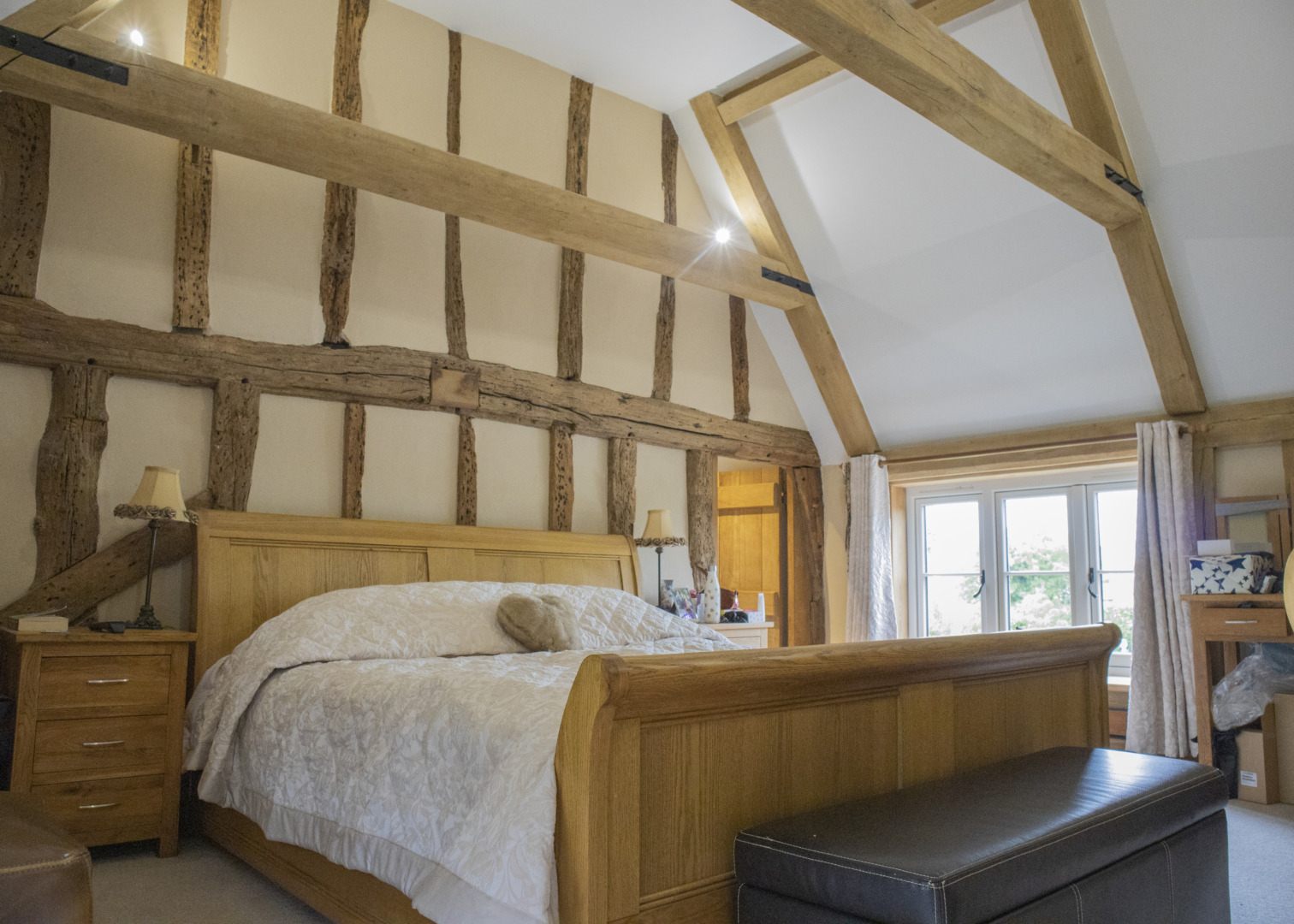 Bedroom with exposed beams and vaulted ceiling and low timber casement window
